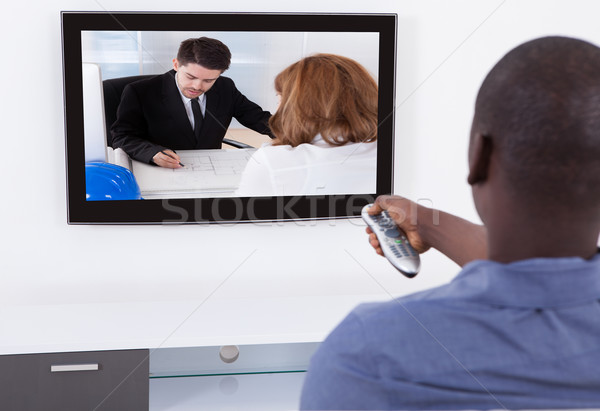 Férfi távoli tv nézés hátsó nézet afrikai televízió Stock fotó © AndreyPopov