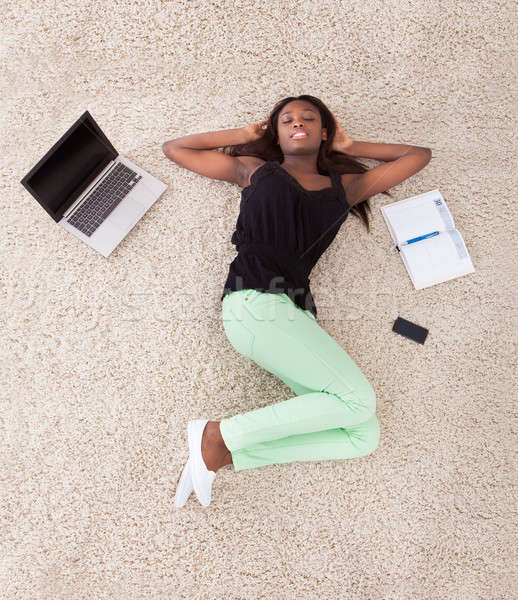 Young African American woman relaxing on rug at home Stock photo © AndreyPopov