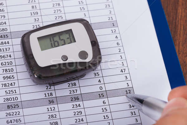 Hand Over Sheet With Digital Pedometer Stock photo © AndreyPopov
