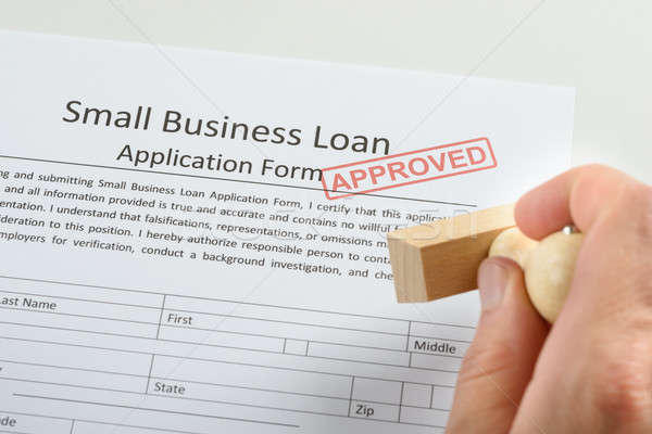 Person Hand Holding Rubber Stamp Over Loan Application Stock photo © AndreyPopov