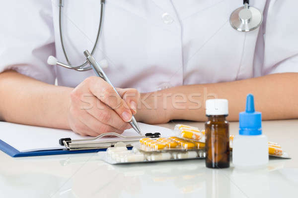 Doctor Writing Prescription On Clipboard Stock photo © AndreyPopov