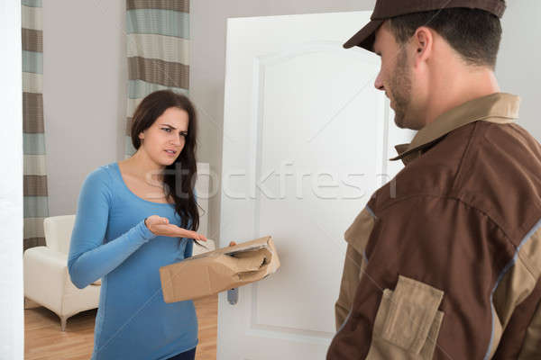 Woman Holding Damaged Package From Delivery Man Stock photo © AndreyPopov
