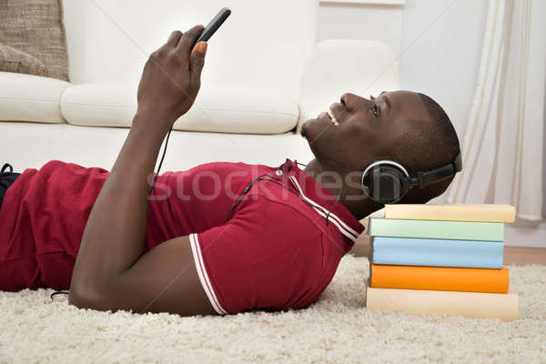 Man Lying On Stack Of Books Listening Music Stock photo © AndreyPopov