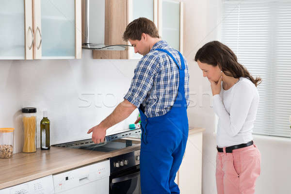 Woman Looking At Worker Repairing Induction Hob Stock photo © AndreyPopov
