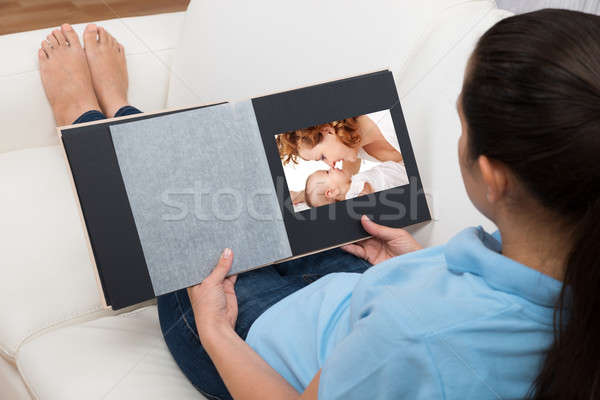 Woman Looking At Photo In Living Room Stock photo © AndreyPopov