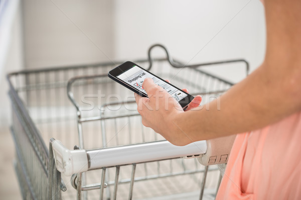 Femeie cumpărături listă smartphone supermarket mâini Imagine de stoc © AndreyPopov