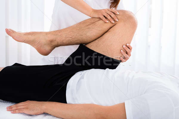 Masseur Giving Leg Massage To Man Stock photo © AndreyPopov