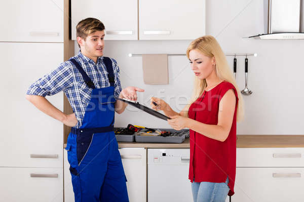 Woman Arguing With Plumber Over Bill In The Kitchen Stock photo © AndreyPopov