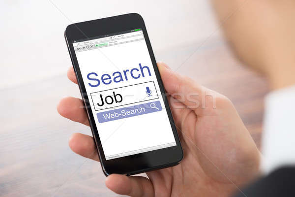 Hand Holding Mobile Phone Showing Job Search Engine Stock photo © AndreyPopov
