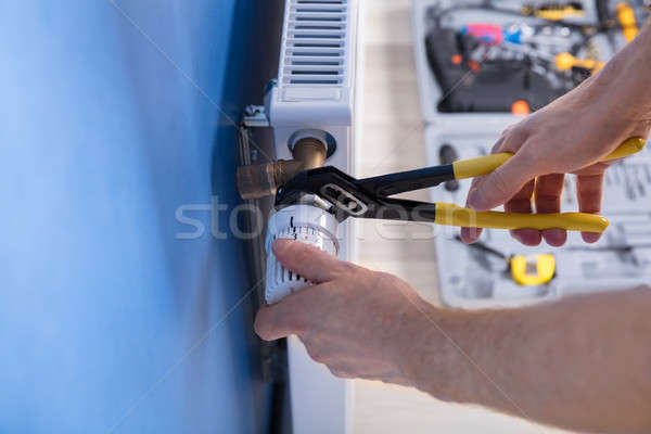 Repairman Fixing Radiator With Wrench Stock photo © AndreyPopov