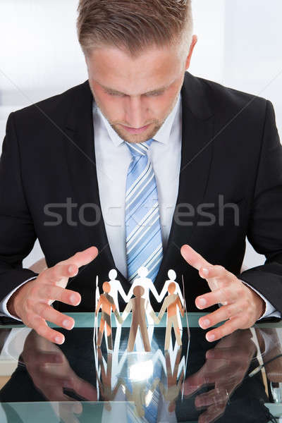 Businessman Taking Care Of Paper People Stock photo © AndreyPopov