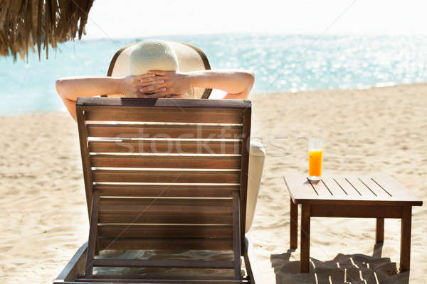 Stock photo: Woman relaxing on deck chair at beach resort