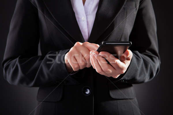 Businessperson Holding Black Cellphone Over Black Background Stock photo © AndreyPopov