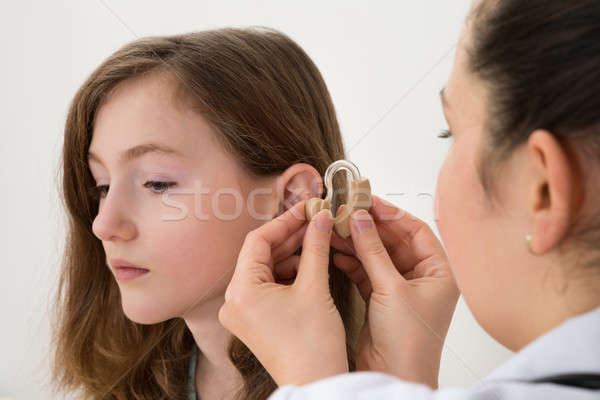 Médico audífono oído nina primer plano mujer Foto stock © AndreyPopov