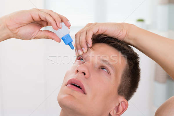 Férfi áramló gyógyszer cseppek szemek közelkép Stock fotó © AndreyPopov
