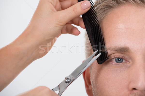 Man Getting His Eyebrow Trimmed Against White Background Stock photo © AndreyPopov