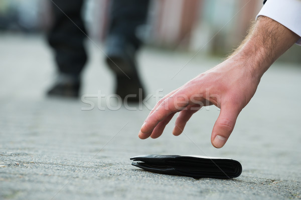 Businessman Picking Up Fallen Wallet On Street Stock photo © AndreyPopov