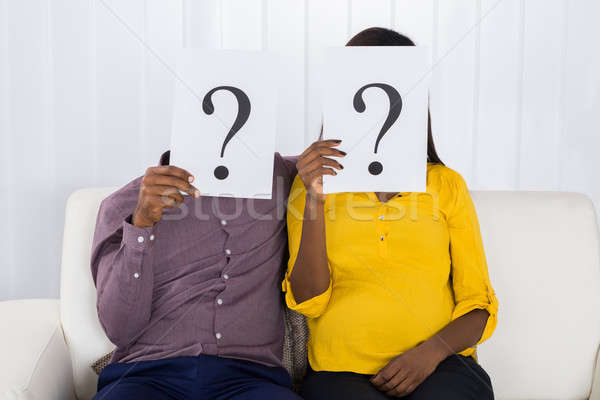 Stock photo: Couple Holding Question Mark Sign In Front Of Face