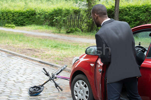 Young African Male Driver Looking At Bicycle Stock photo © AndreyPopov