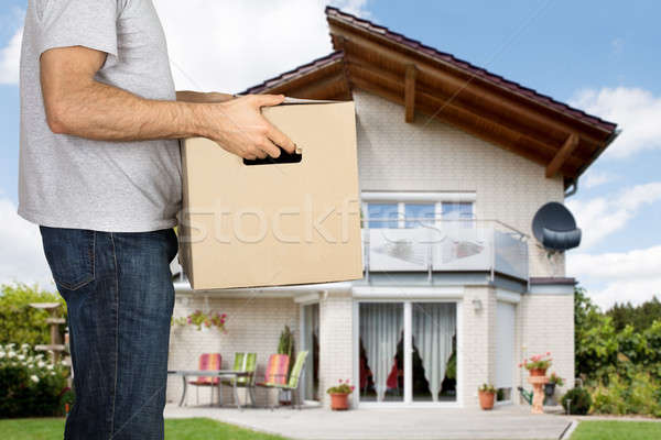 Man Holding Cardboard Box In Front Of His House Stock photo © AndreyPopov