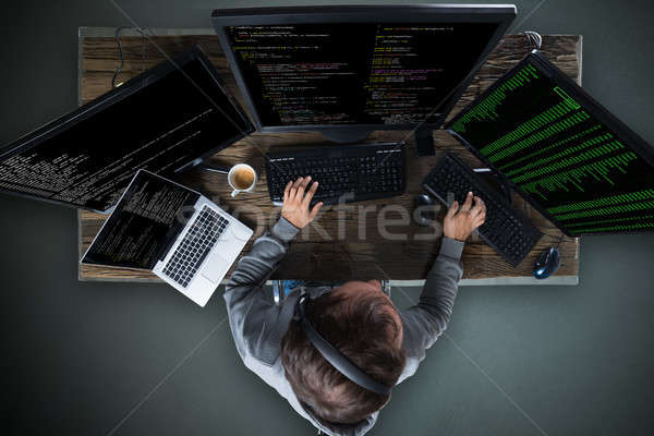 Hacker Hacking Multiple Computers On Desk Stock photo © AndreyPopov