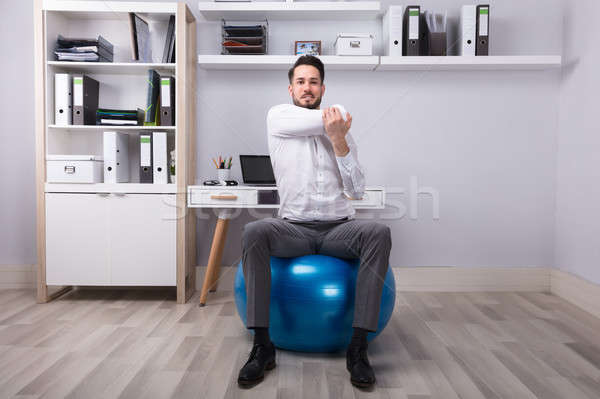 Zdjęcia stock: Biznesmen · wykonywania · posiedzenia · fitness · piłka · działalności