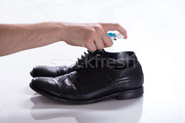 Man Spreading Deodorant On Smelly Shoes Stock photo © AndreyPopov