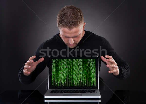 Man or hacker stealing data from a laptop at night Stock photo © AndreyPopov