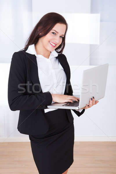 Welldressed Businesswoman Using Laptop In Office Stock photo © AndreyPopov