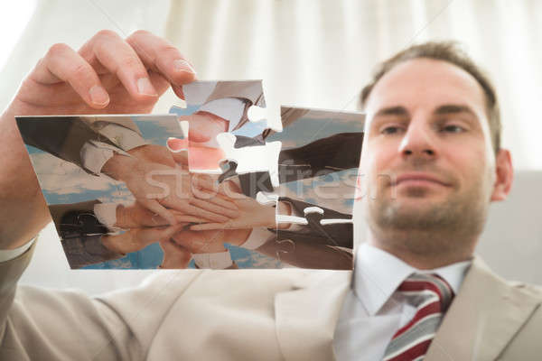 Businessman Inserting Last Puzzle Piece Stock photo © AndreyPopov