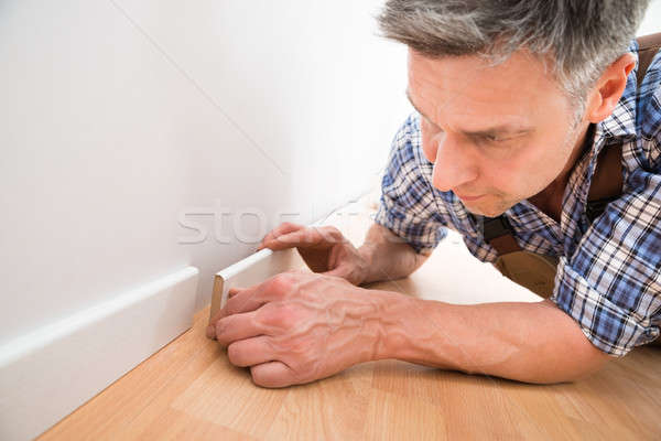 Carpenter Applying Skirting On Wall Stock photo © AndreyPopov