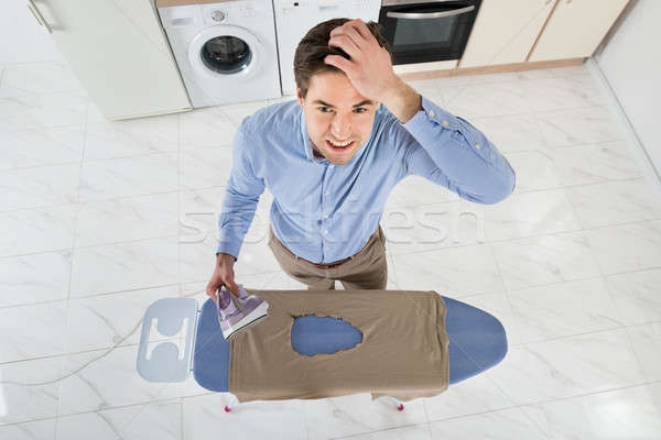 Man With Electric Iron And Burned Iron Cloth Stock photo © AndreyPopov