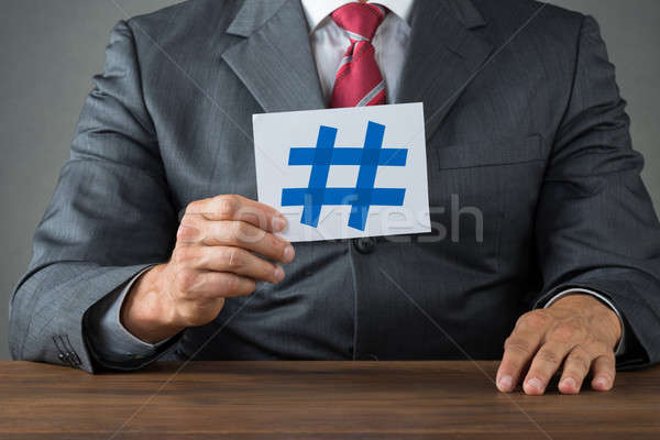 Businessman Showing Hash Sign At Desk Stock photo © AndreyPopov