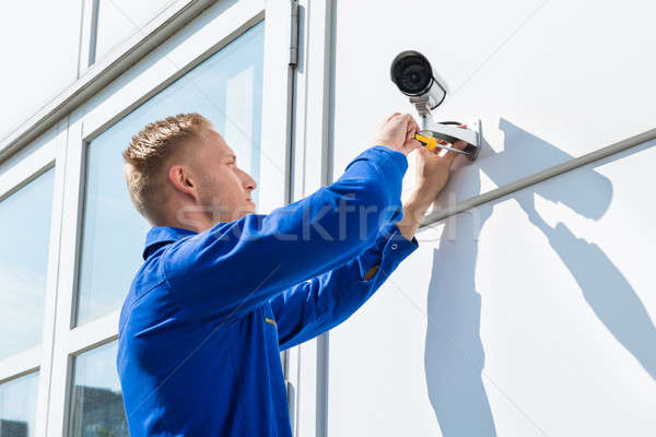 Technician Fixing Camera On Wall Stock photo © AndreyPopov