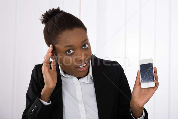 Worried Businesswoman Holding Smartphone With Cracked Screen Stock photo © AndreyPopov