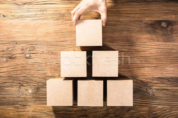 Person Holding Block On Wooden Table Stock photo © AndreyPopov