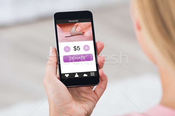 Woman Holding Mobile Phone Donating Money Stock photo © AndreyPopov