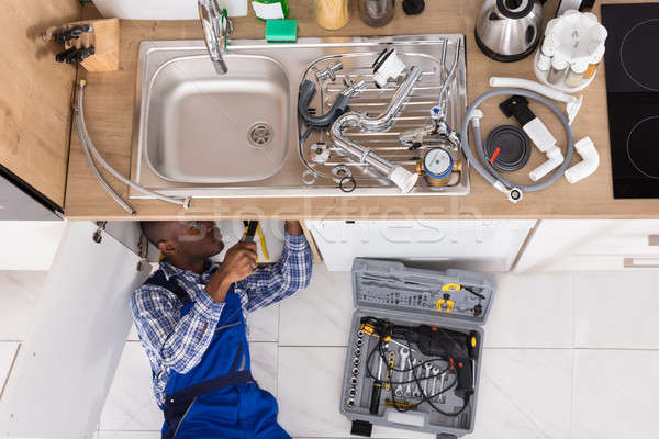 Handyman Lying On Floor Repairing Sink Stock photo © AndreyPopov