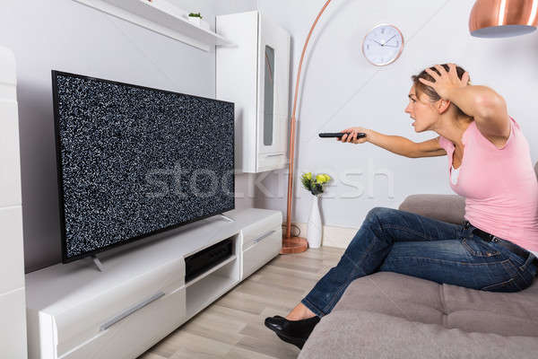 Woman Frustrated With A TV Screen Glitch Stock photo © AndreyPopov