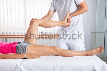 Physiotherapist Giving Leg Exercise To Patient Stock photo © AndreyPopov