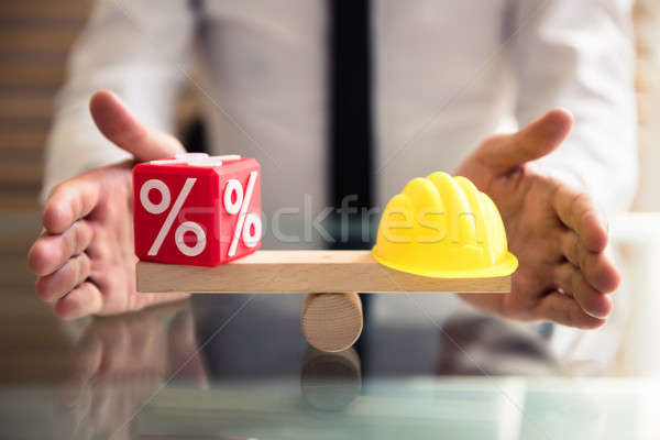 Stock photo: Hand Protecting Balance Between Percentage And Yellow Hardhat