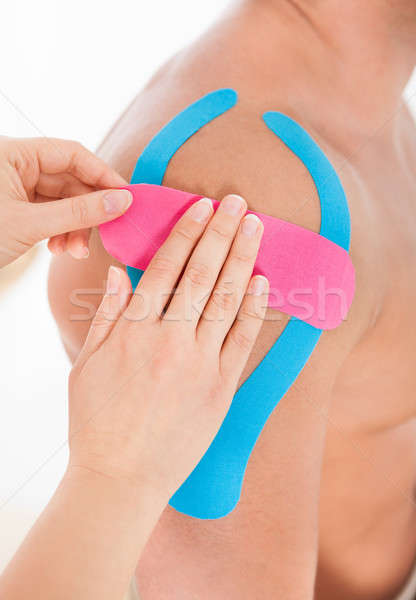 Stock photo: Applying Special Physio Tape On Man's Shoulder