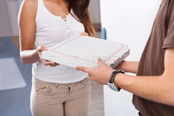 Woman Receiving Pizza From Delivery Man Stock photo © AndreyPopov