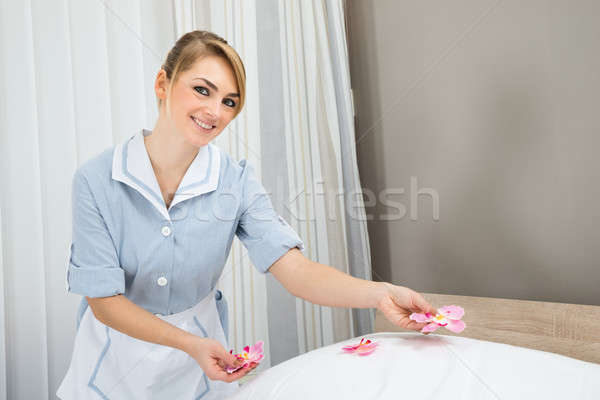 Housekeeper Decorating Bed With Petals Stock photo © AndreyPopov