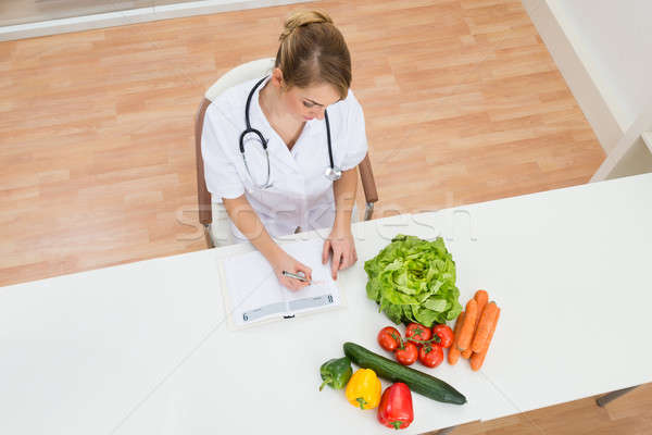 Female Dietician Writing In Diary Stock photo © AndreyPopov