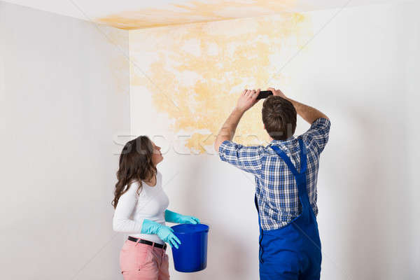 Handyman With Woman Photographing Ceiling At Home Stock photo © AndreyPopov