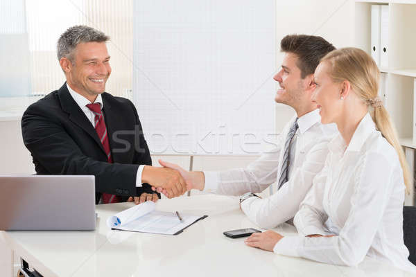 агент по продаже недвижимости рукопожатием пару молодые счастливым столе Сток-фото © AndreyPopov