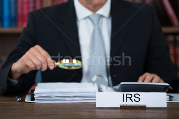 Könyvvizsgáló megvizsgál iratok nagyító asztal adó Stock fotó © AndreyPopov