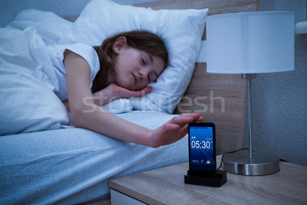 Somnoros fată alarmă smartphone cameră Imagine de stoc © AndreyPopov