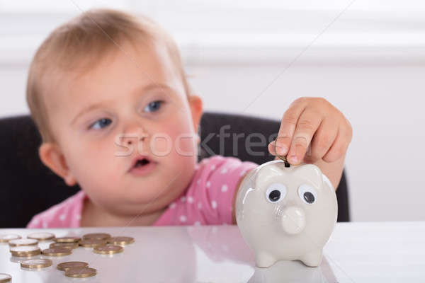 Baby Inserting Coin In Piggybank Stock photo © AndreyPopov